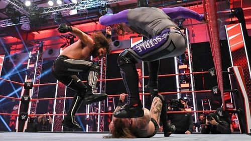 Aleister Black being beaten down by Seth Rollins and Murphy