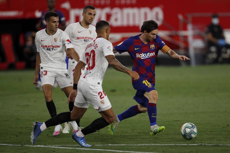 Diego Carlos of Sevilla challenges Lionel Messi of Barcelona