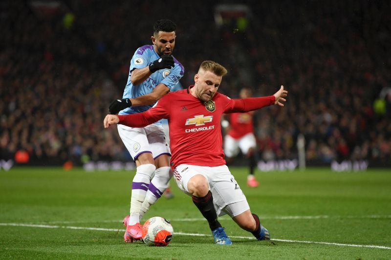 Riyad Mahrez of Manchester City battles for possession with Luke Shaw of Manchester United