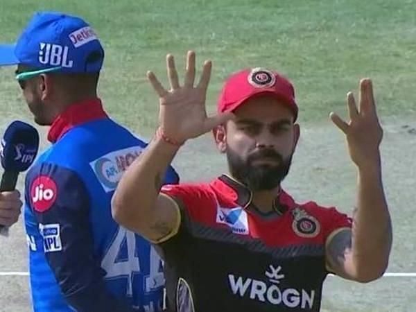 Virat Kohli signalling to his team after a toss in a different game