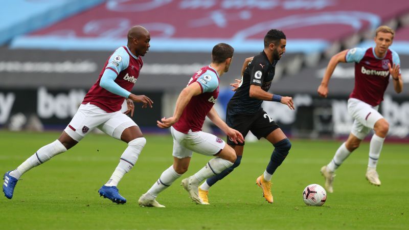 Riyad Mahrez of Manchester City runs with the ball surrounded by West Ham United players