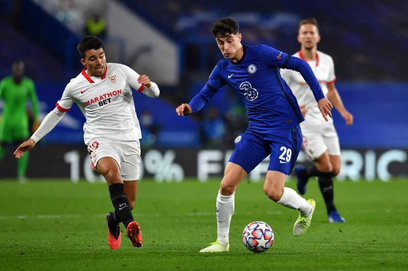 Kai Havertz of Chelsea runs with the ball with pressure from Marcos Acuna of Sevilla.