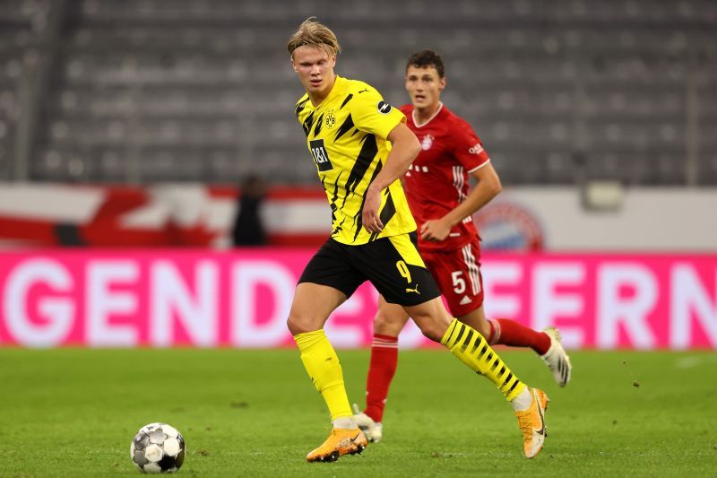 Haaland of Borussia Dortmund runs with the ball during the game as Benjamin Pavard looks on.