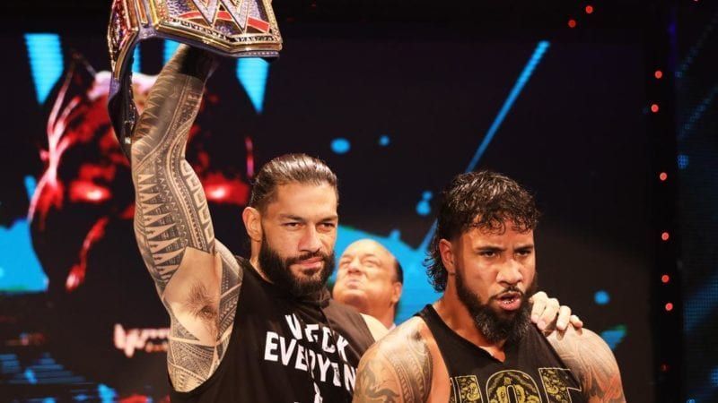 Roman Reigns and Jey Uso with Paul Heyman in the background