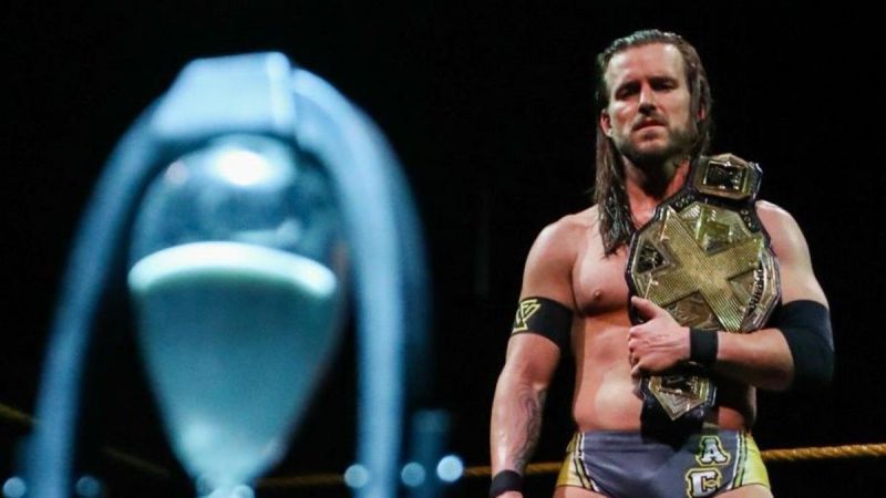 Adam Cole staring at the hourglass left by Scarlett