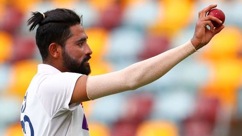 Mohammed Siraj raises the ball after picking up his maiden five-wicket haul at the Gabba.