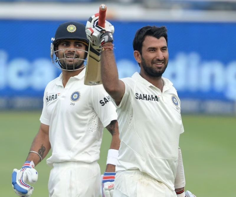 Cheteshwar Pujara (right) celebrates his hundred in Johannesburg in December 2013.