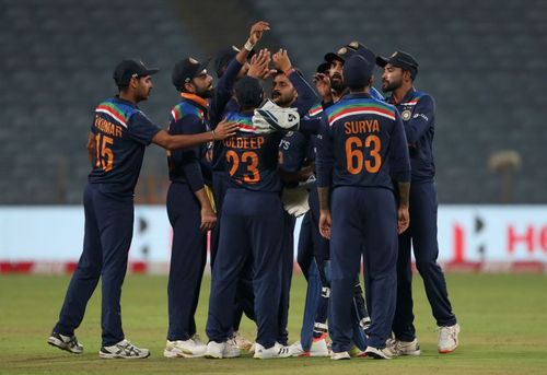 The Indian cricket team celebrating the fall of a wicket.