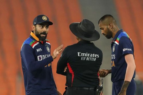 Virat Kohli engaging in a tense chat with umpire Nitin Menon after Jos Buttler's dismissal.