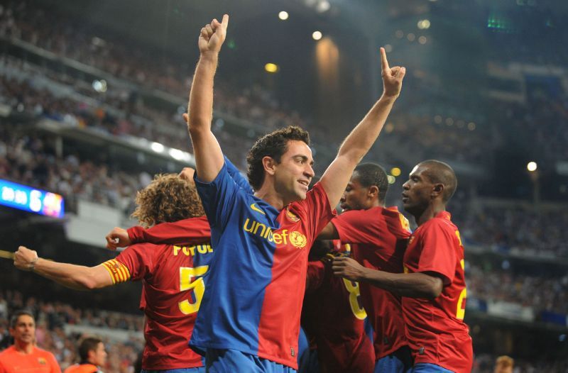 Xavi celebrates with teammates after providing four assists in an El Clasico