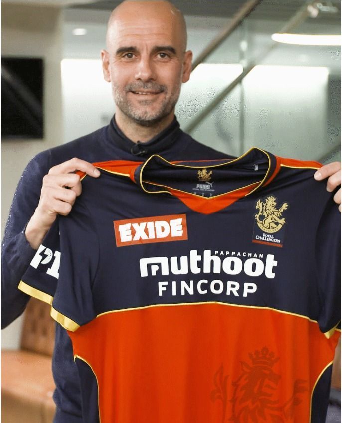 Manchester City manager Pep Guardiola showing off the RCB jersey