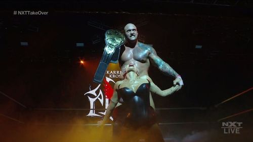 Karrion Kross posing with Scarlett after becoming a two-time NXT Champion