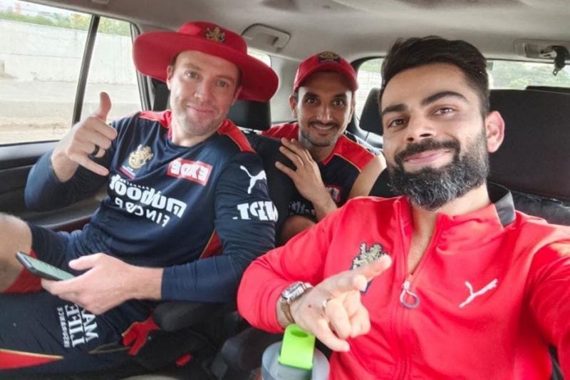 Harshal Patel alongside AB de Villiers (L) and Virat Kohli (R) during IPL 2021