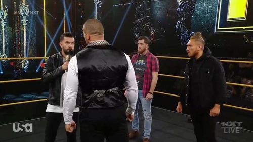 Karrion Kross being confronted by Finn Balor, Kyle O'Reilly, and Pete Dunne