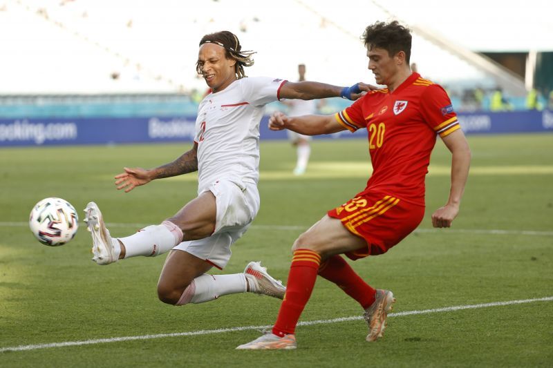 : Daniel James of Wales crosses the ball whilst under pressure from Kevin Mbabu of Switzerland