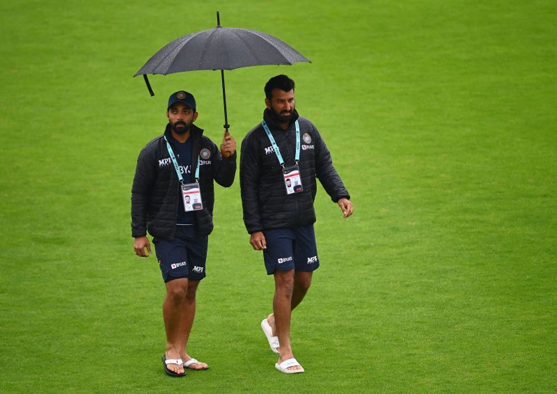 Ajinkya Rahane (L) and Chestehwar Pujara (R) walking on the outfield before start of play