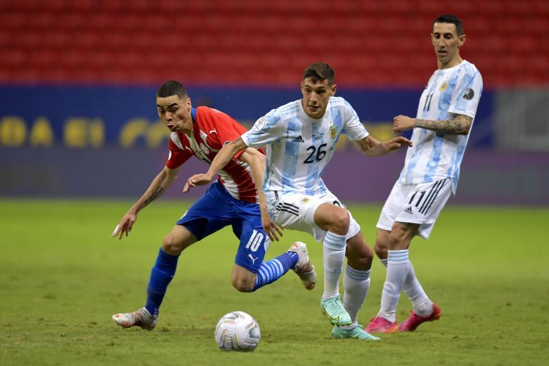 Angel di Maria (right) and Nahuel Molina (centre) fight for the ball against Paraguay&#039;s Miguel Almiron