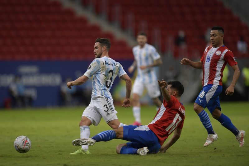 Nicolas Tagliafico (left) is challenged by a Paraguay defender