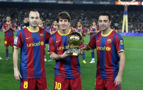 Messi posing with his second Ballon d'Or at the Camp Nou alongside Iniesta and Xavi