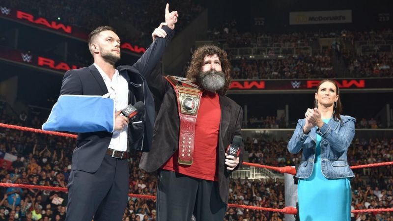 Finn Balor handing over the Universal Championship on RAW