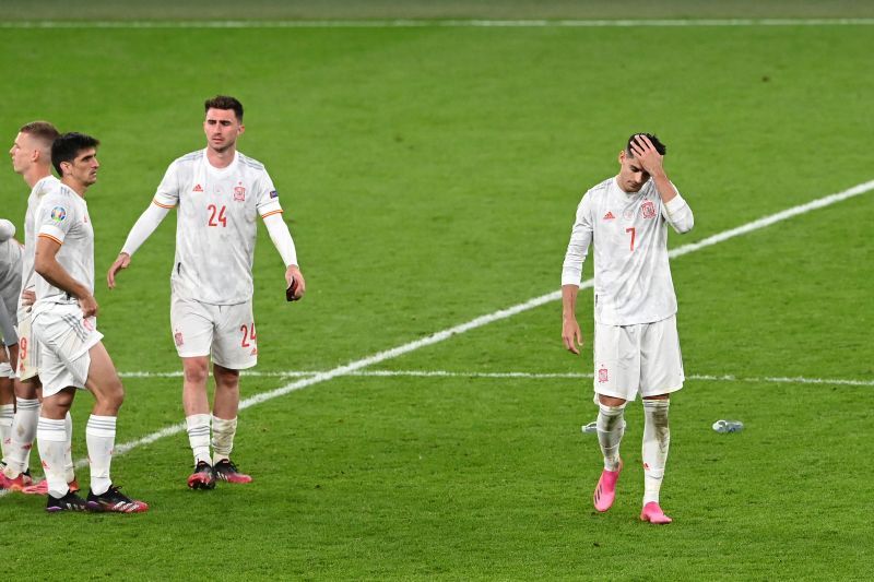 A dejected Alvaro Morata (right) beats a forlorn retreat from the Wembley pitch after his missed penalty.