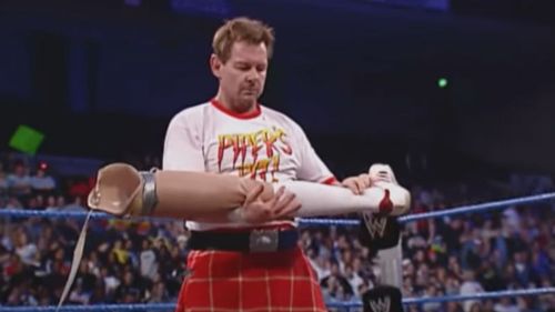 Roddy Piper holding Zach Gowen's prosthetic leg