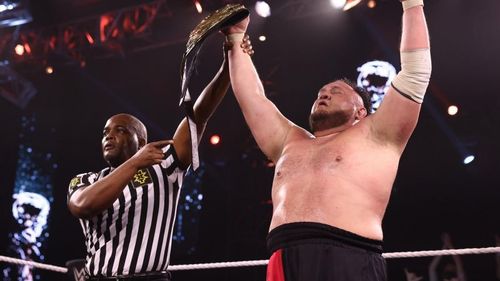 Samoa Joe lifting the NXT Championship after defeating Karrion Kross