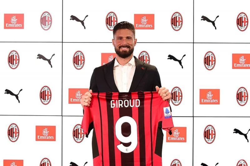 Olivier Giroud holding his number 9 AC Milan jersey