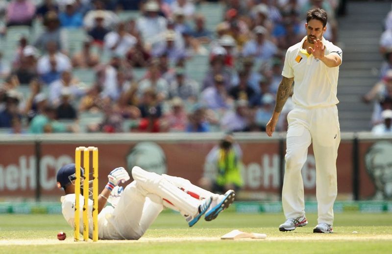 Kohli falls onto the ground after being hit by Mitchell Johnson in a run out attempt