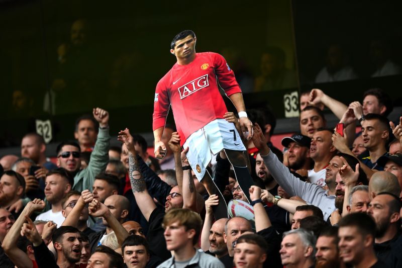 Manchester United fans holding up a cut-out of Cristiano Ronaldo