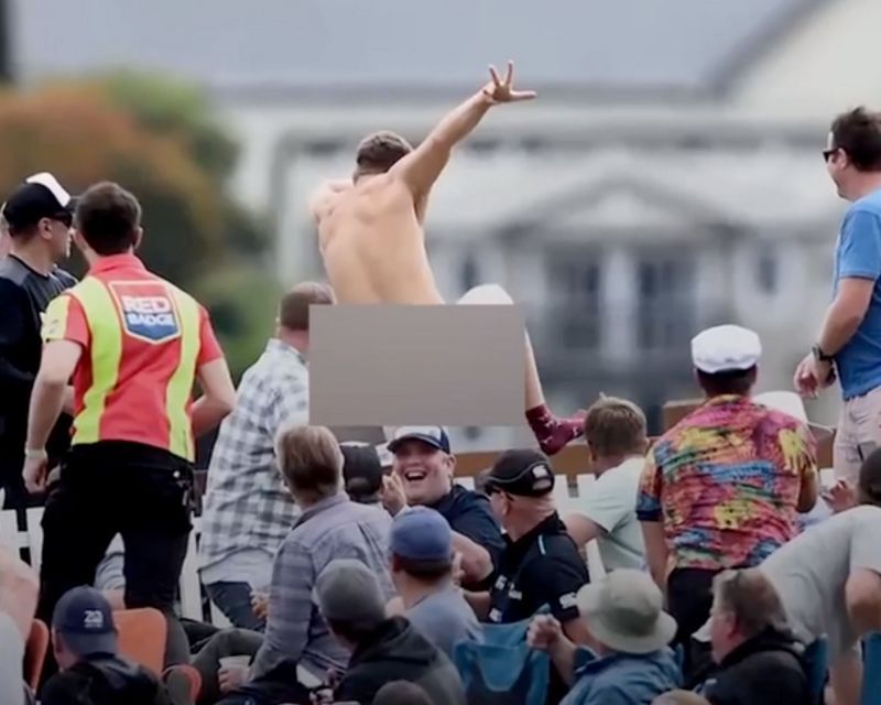 A fan running back into the stands after escaping into the cricket field