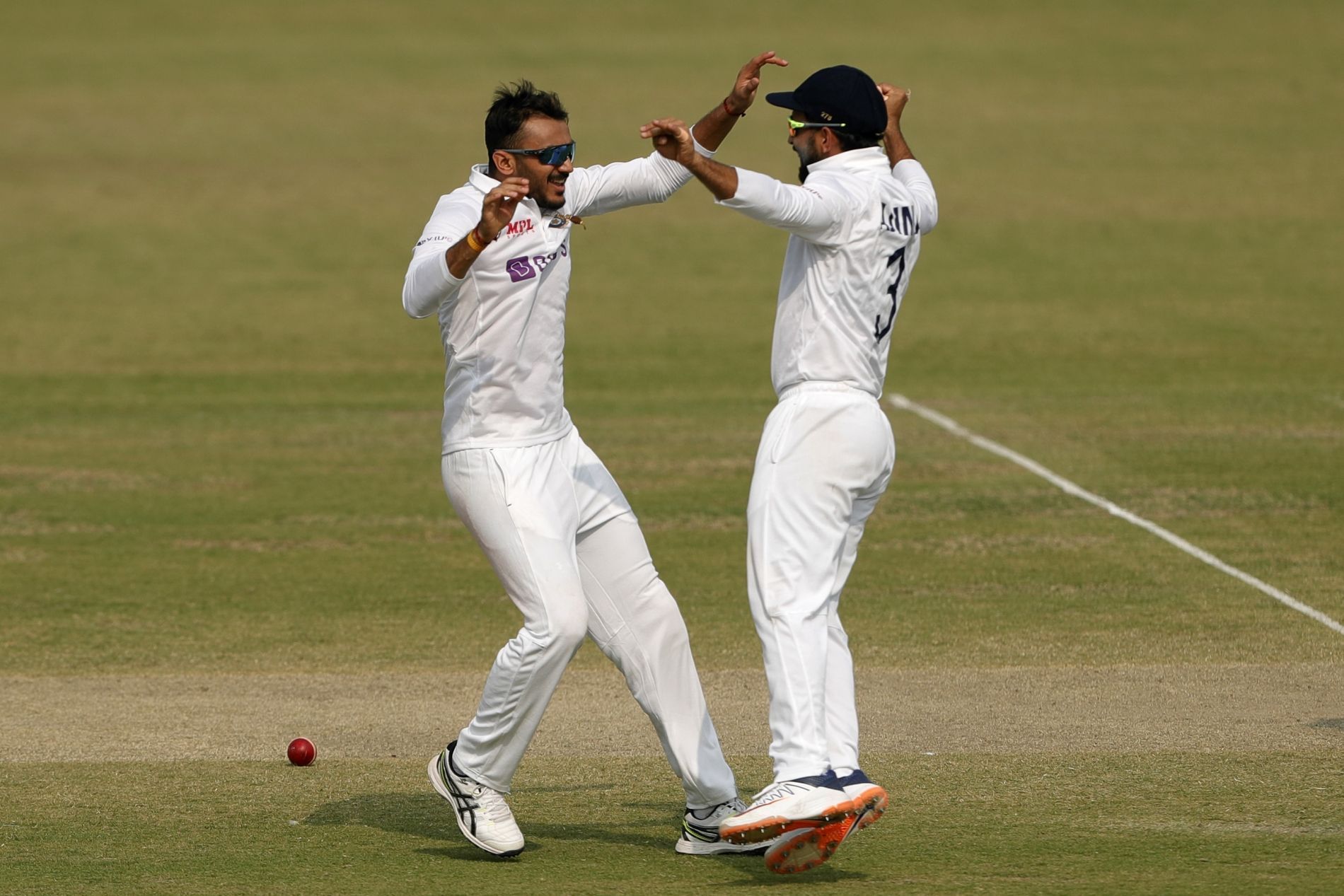 Axar Patel (left) celebrates one of his five scalps. Pic: ICC