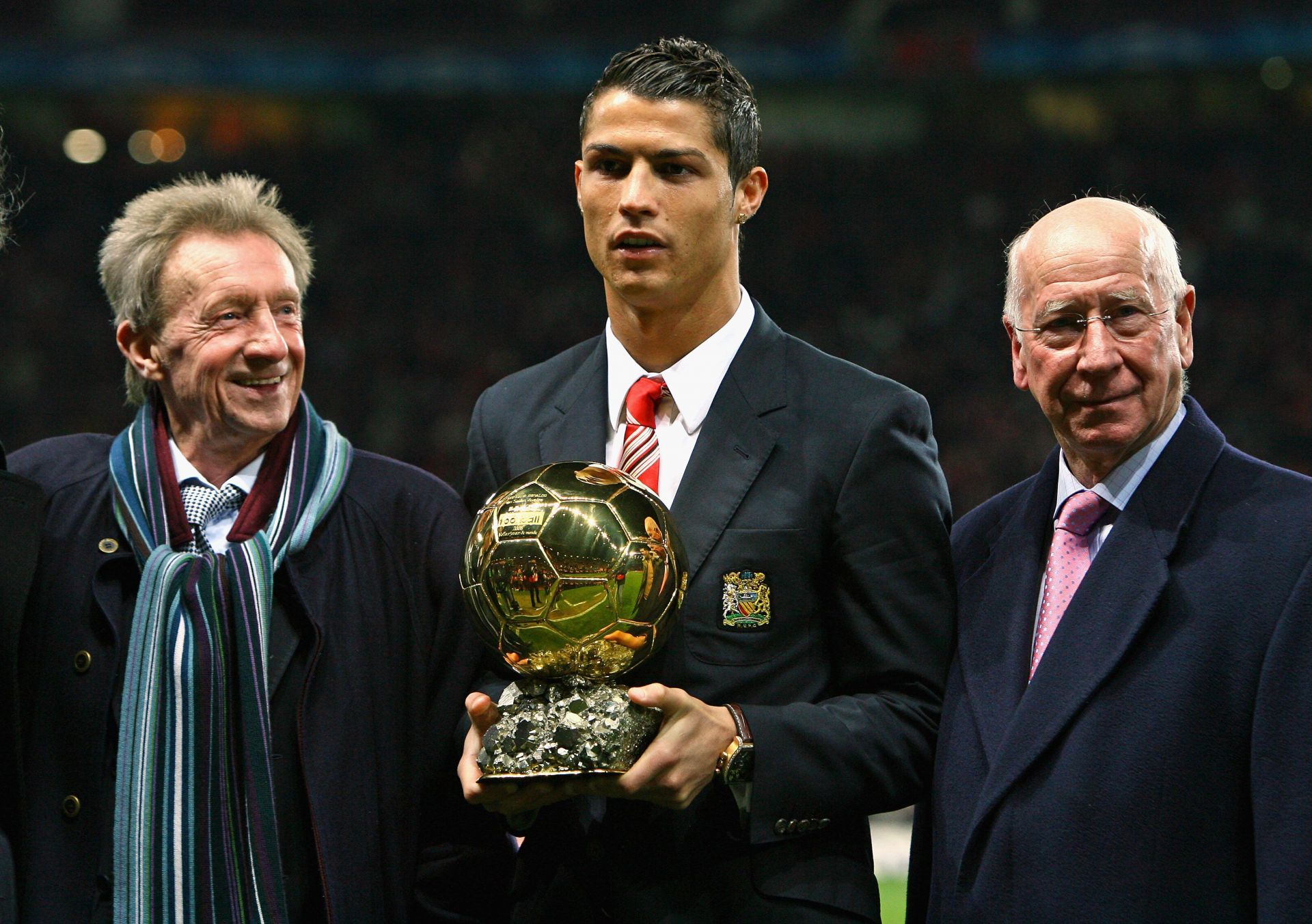 Ronaldo poses with his first Ballon d'Or award, flanked by Dennis Law (left) and Bobby Charlton (right).