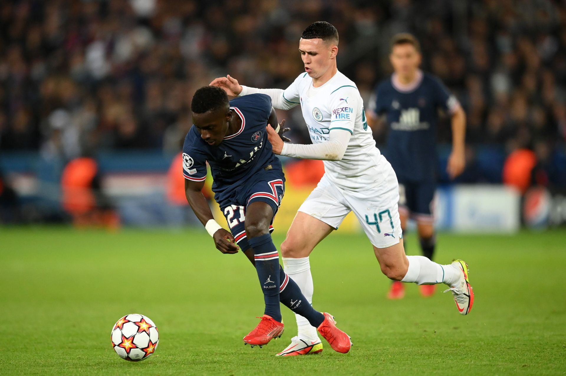 Manchester City's Phil Foden (#47) challenges Idrissa Gueye (L) of PSG