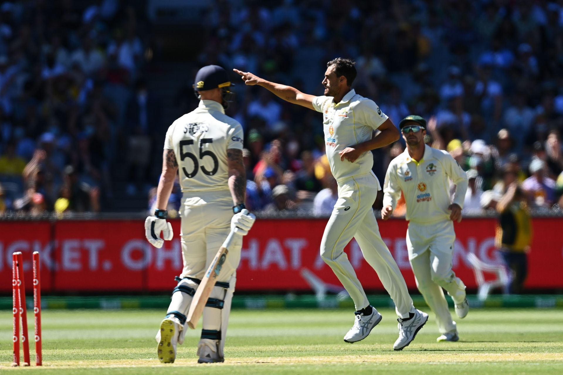 Mitchell Starc celebrates as a dejected Ben Stokes walks back to the pavillion.