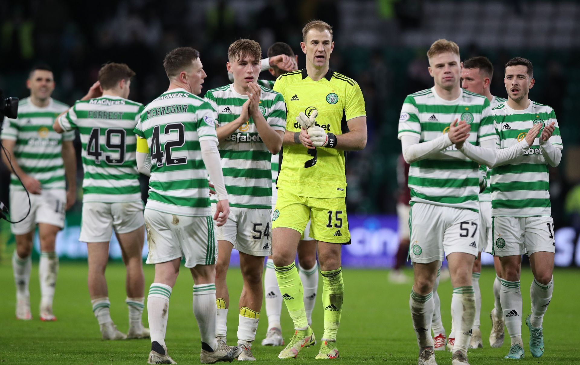 Celtic players applaud their fans at the end of a game.