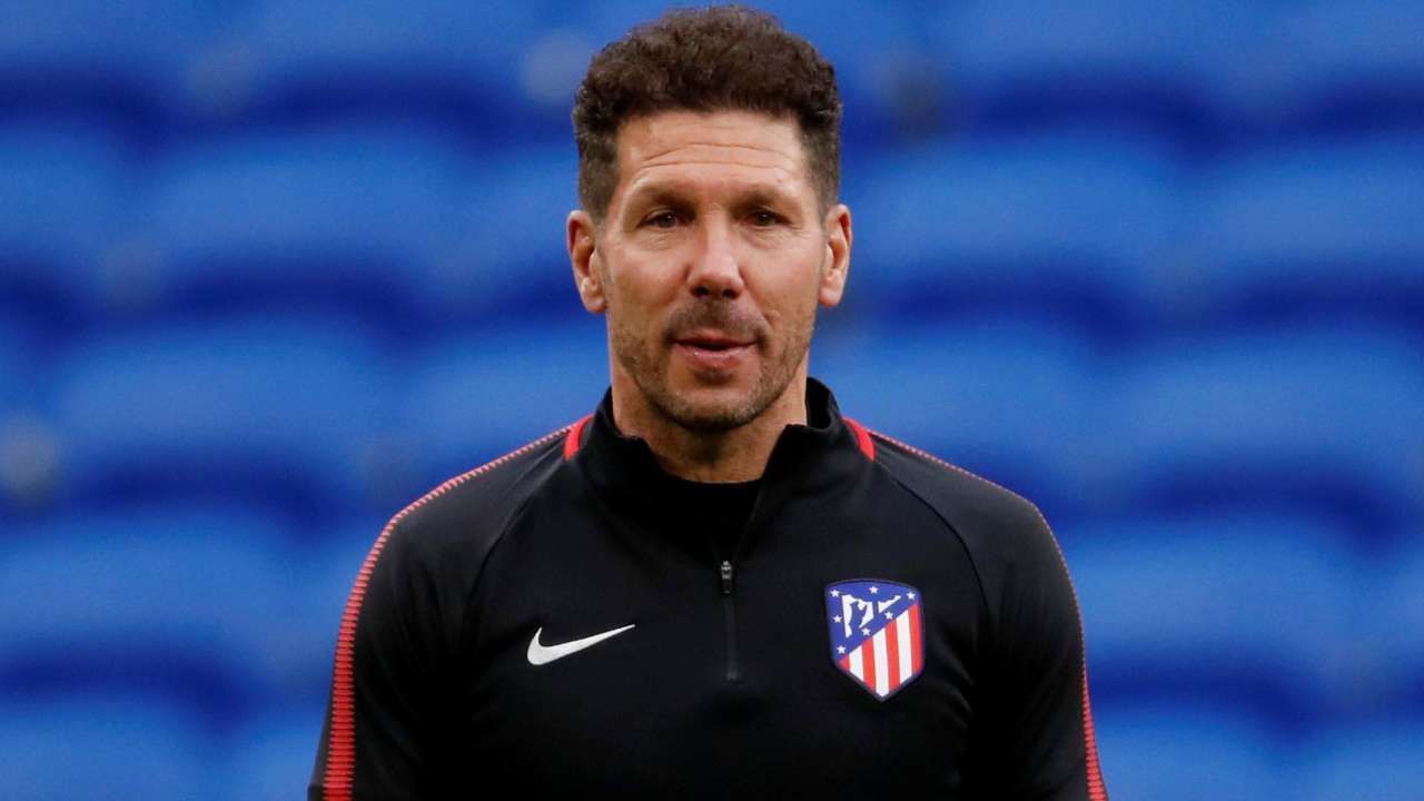 Atletico Madrid coach Diego Simeone watches on as his players warm up before a game.