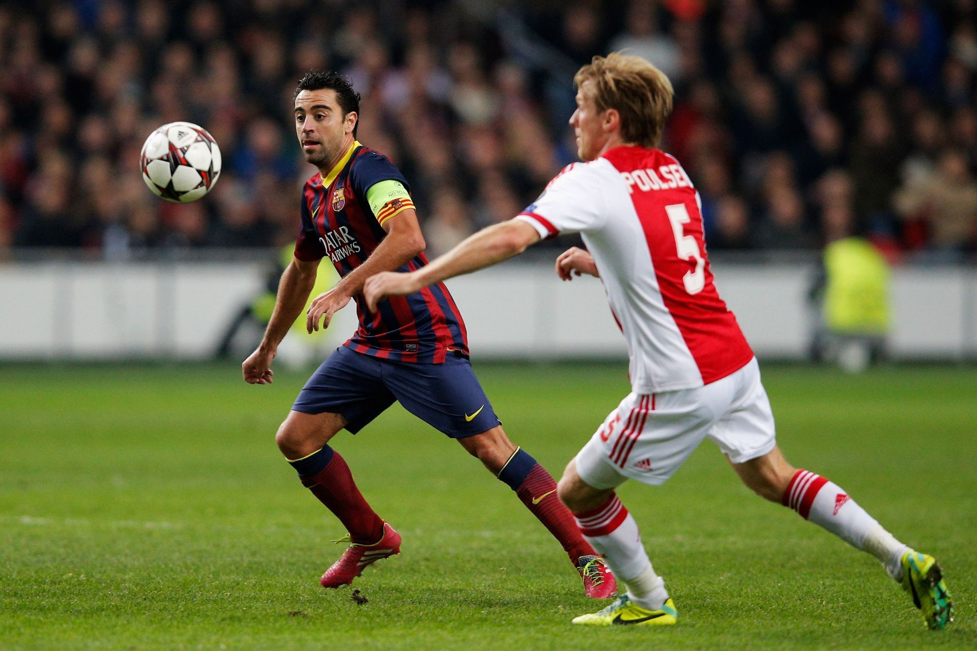 Xavi Hernandez (left) of Barcelona challenged by Ajax&#039;s Poulsen (right, #53)