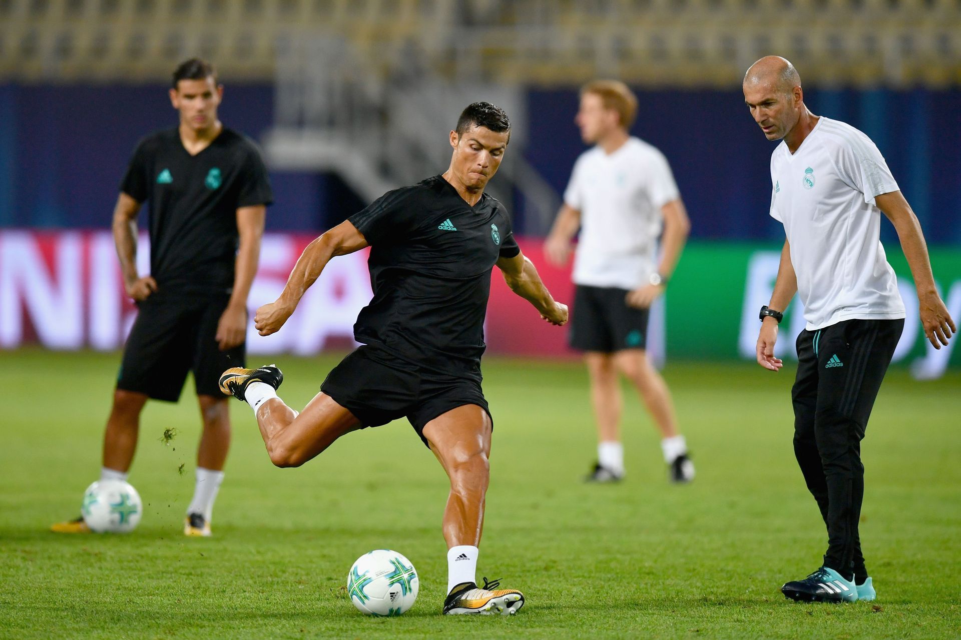 Cristiano Ronaldo warms up while Zinedine Zidane looks on.