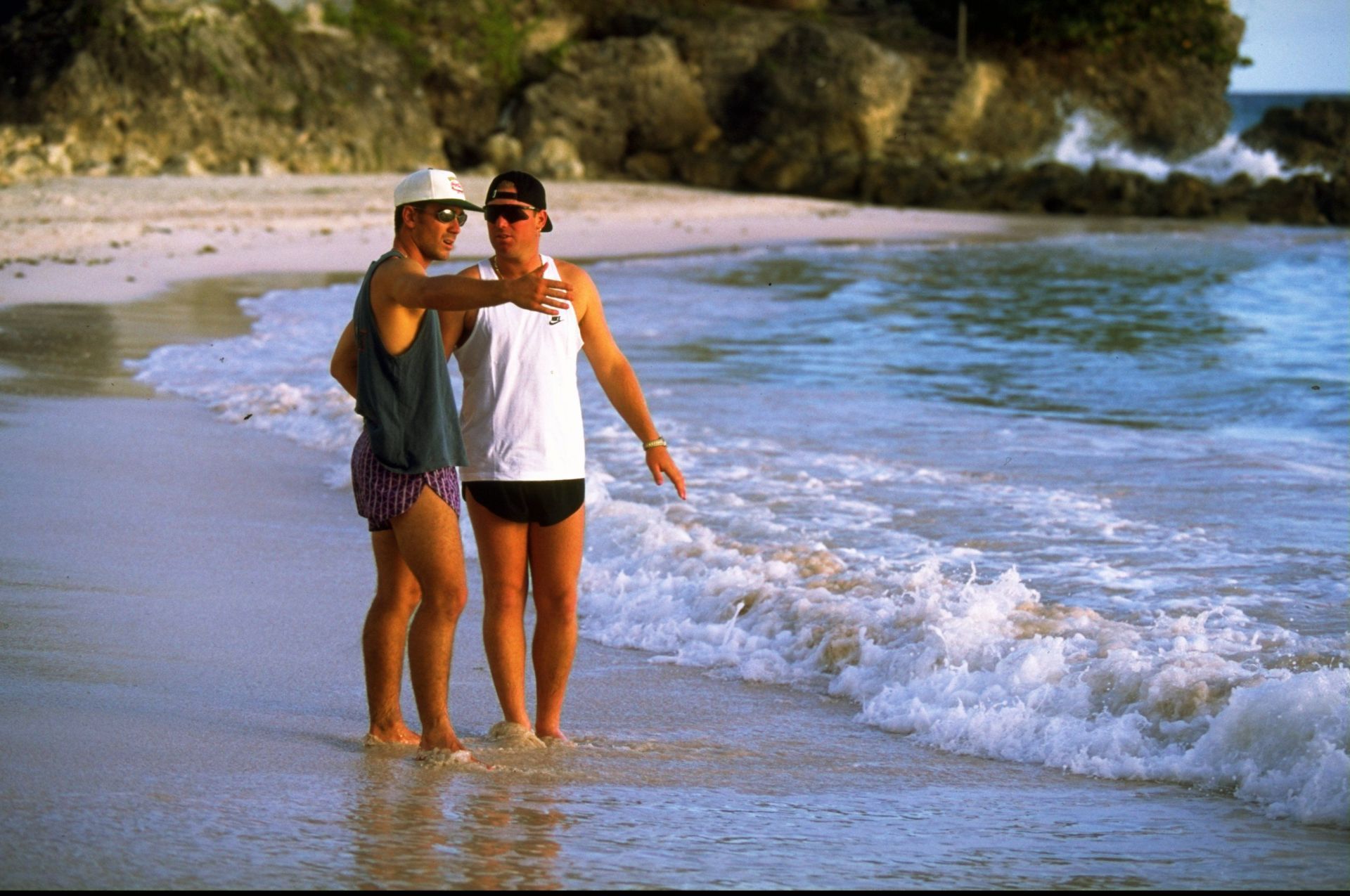 Justin Langer and Shane Warne of Australia relax in the sea during their tour to the West Indies in 1995. Pic: Getty Images