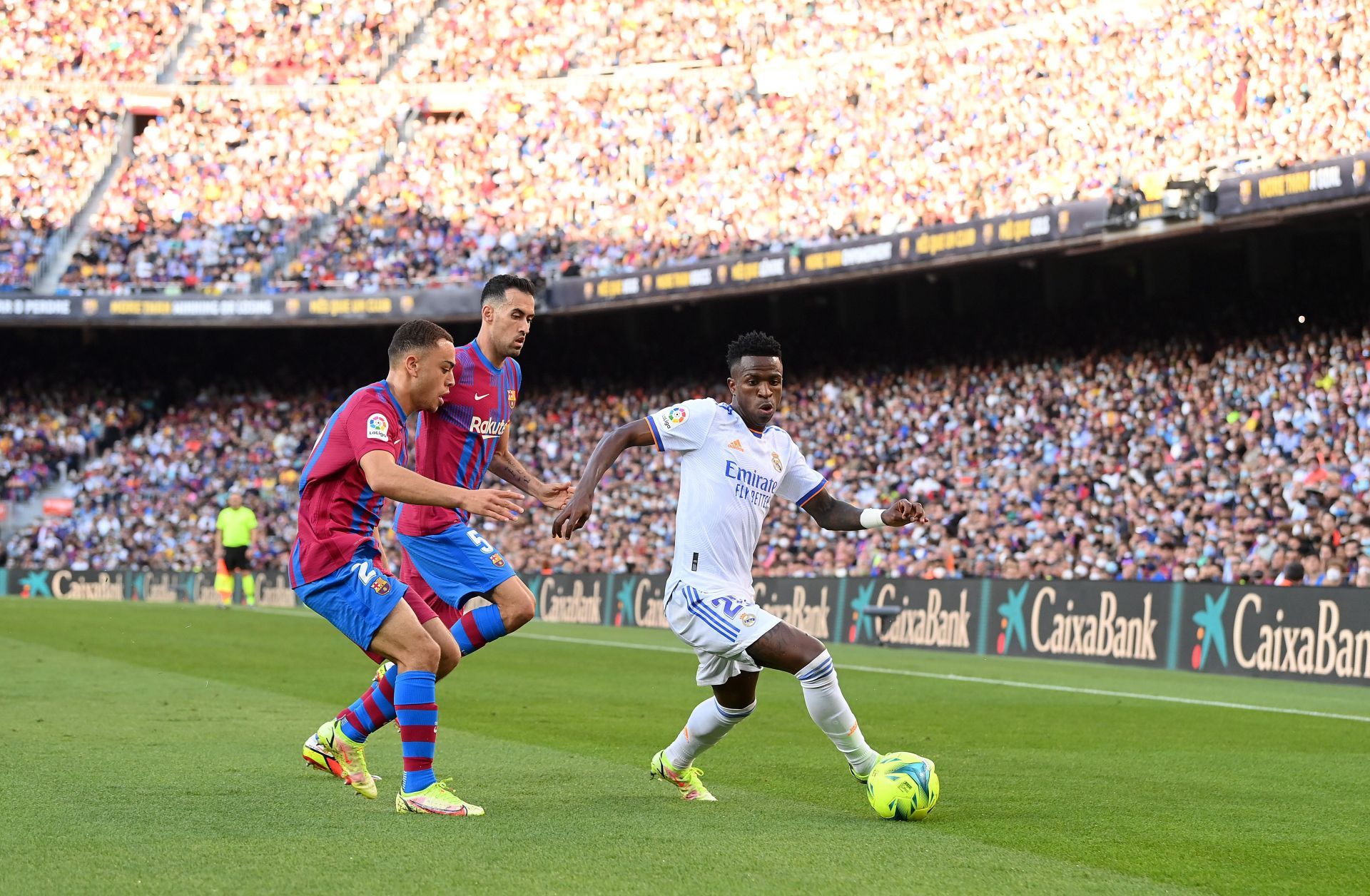 Vinicius Jr. holds off Sergino Dest and Sergio Busquets of FC Barcelona