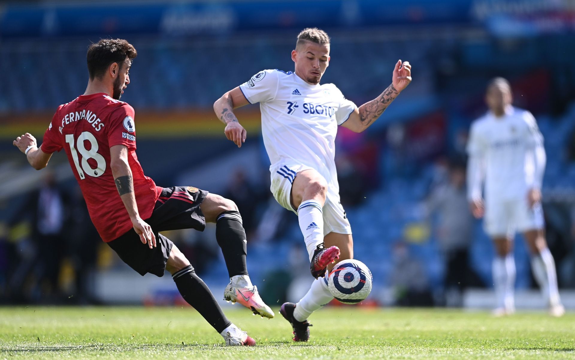 Leeds United&#039;s Kalvin Phillips (R) tackles Bruno Fernandes (L, #18) of Manchester United.