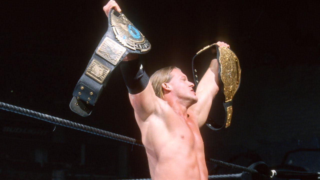 Chris Jericho poses with the two titles