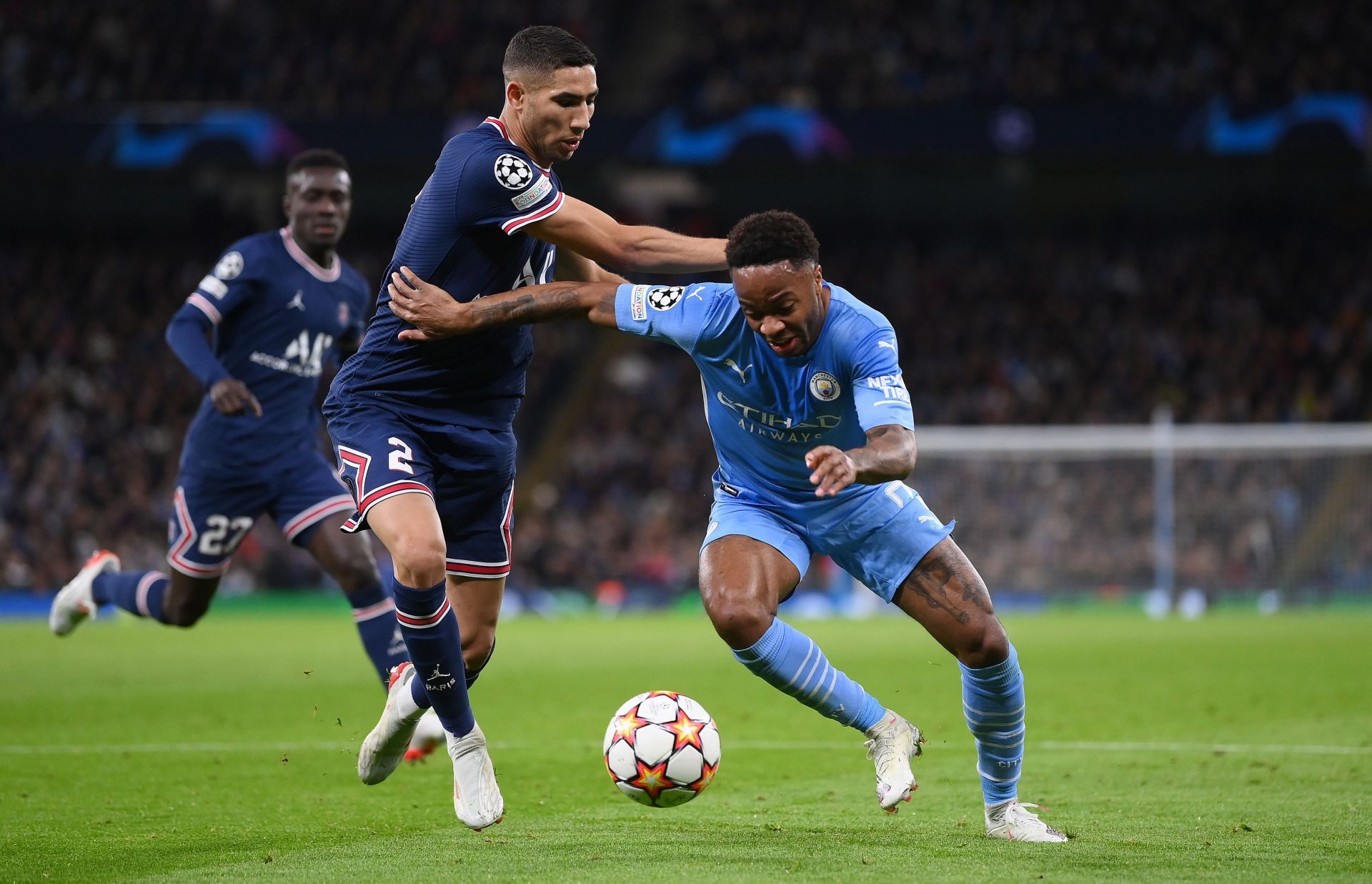 Manchester City's Raheem Sterling (right) drives at the PSG defence.