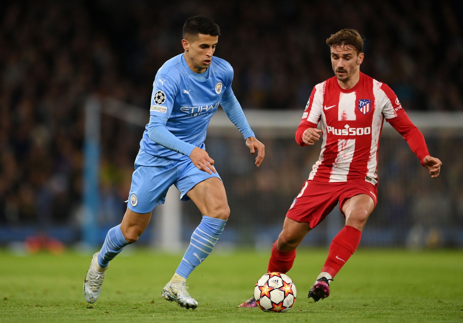 Antoine Griezmann tussles it out with Joao Cancelo.