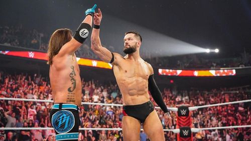 AJ Styles and Finn Balor making the signature 'Too Sweet' gesture of the Bullet Club