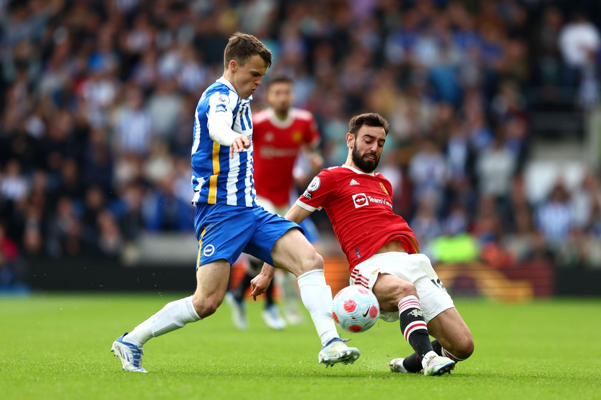 Solly March (L) gets past Manchester United's Bruno Fernandes