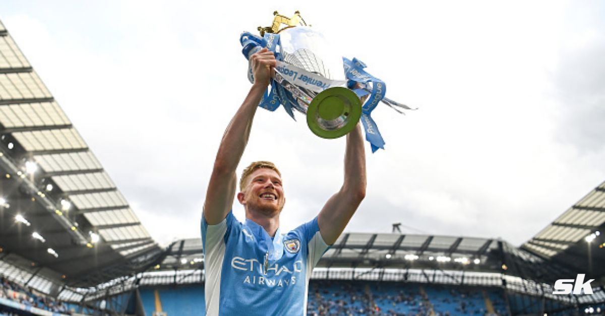 Manchester City midfielder Kevin De Bruyne hoists the Premier League trophy.