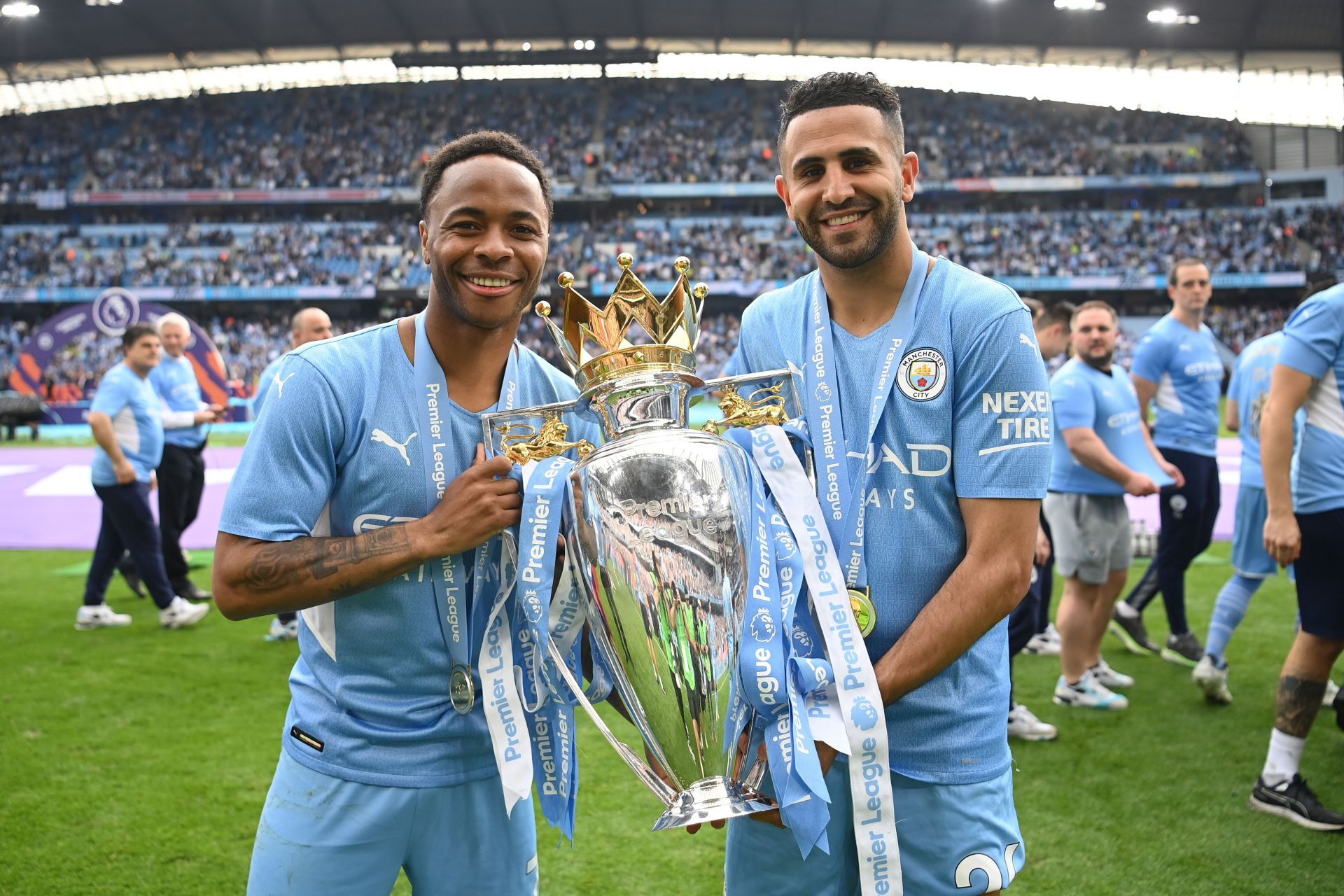 Raheem Sterling poses alongside Riyad Mahrez with the Premier League trophy