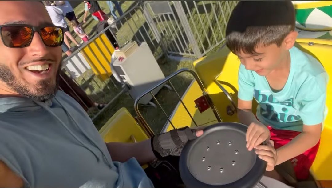 Ali and his son are riding the spinning teacups